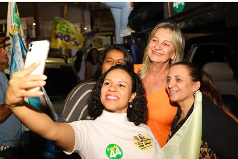 Zeli sorri ao lado de apoiadoras que fazem uma selfie, à noite, nas ruas de Valparaíso.