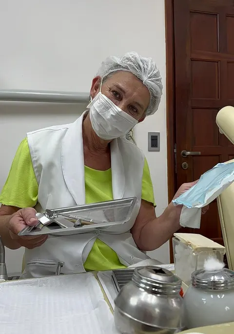 Dra. Zeli de máscara preparando instrumentos odontológicos.